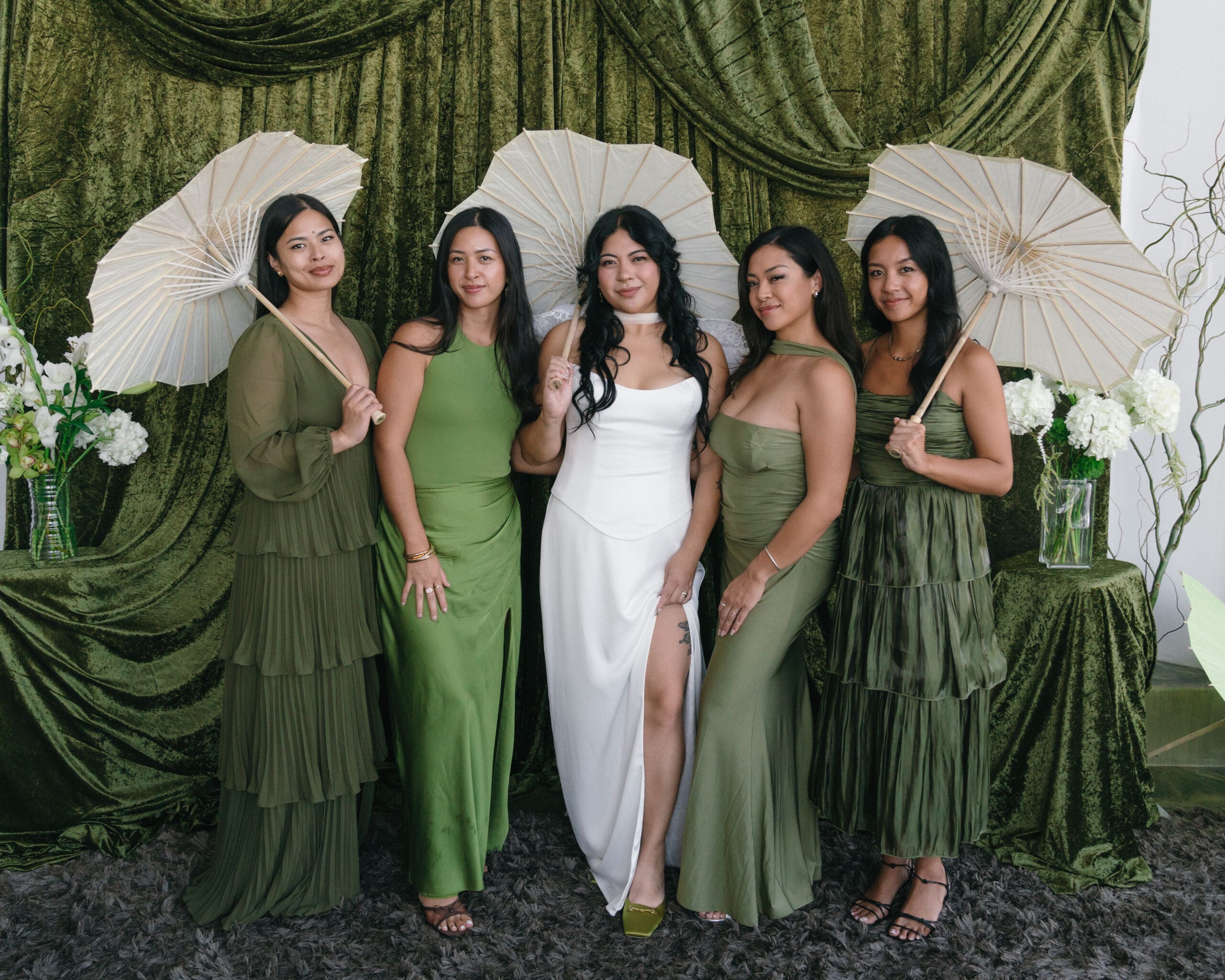 Green, crushed velvet draped photo backdrop for wedding party portraits.